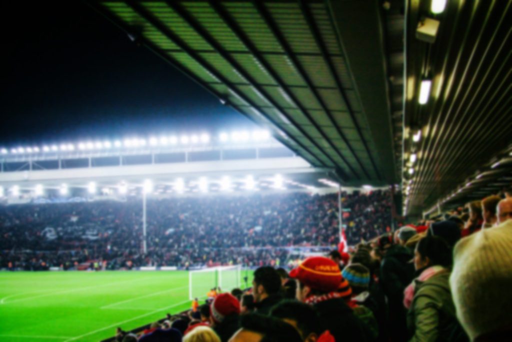 blurred,background,of,football,players,playing,and,soccer,fans,in
