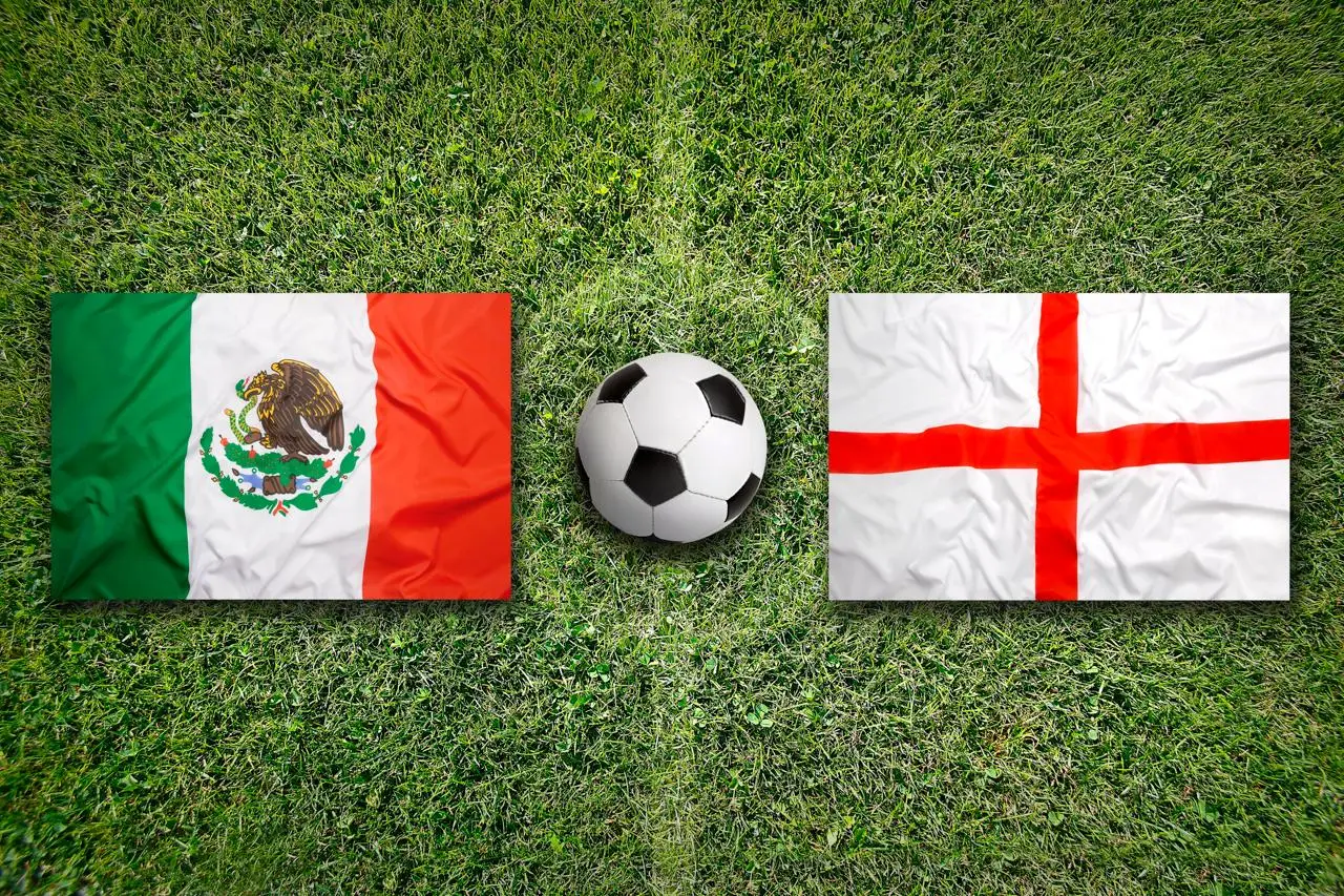 Mexico and England flags on grass with a soccer ball before their World Cup match.