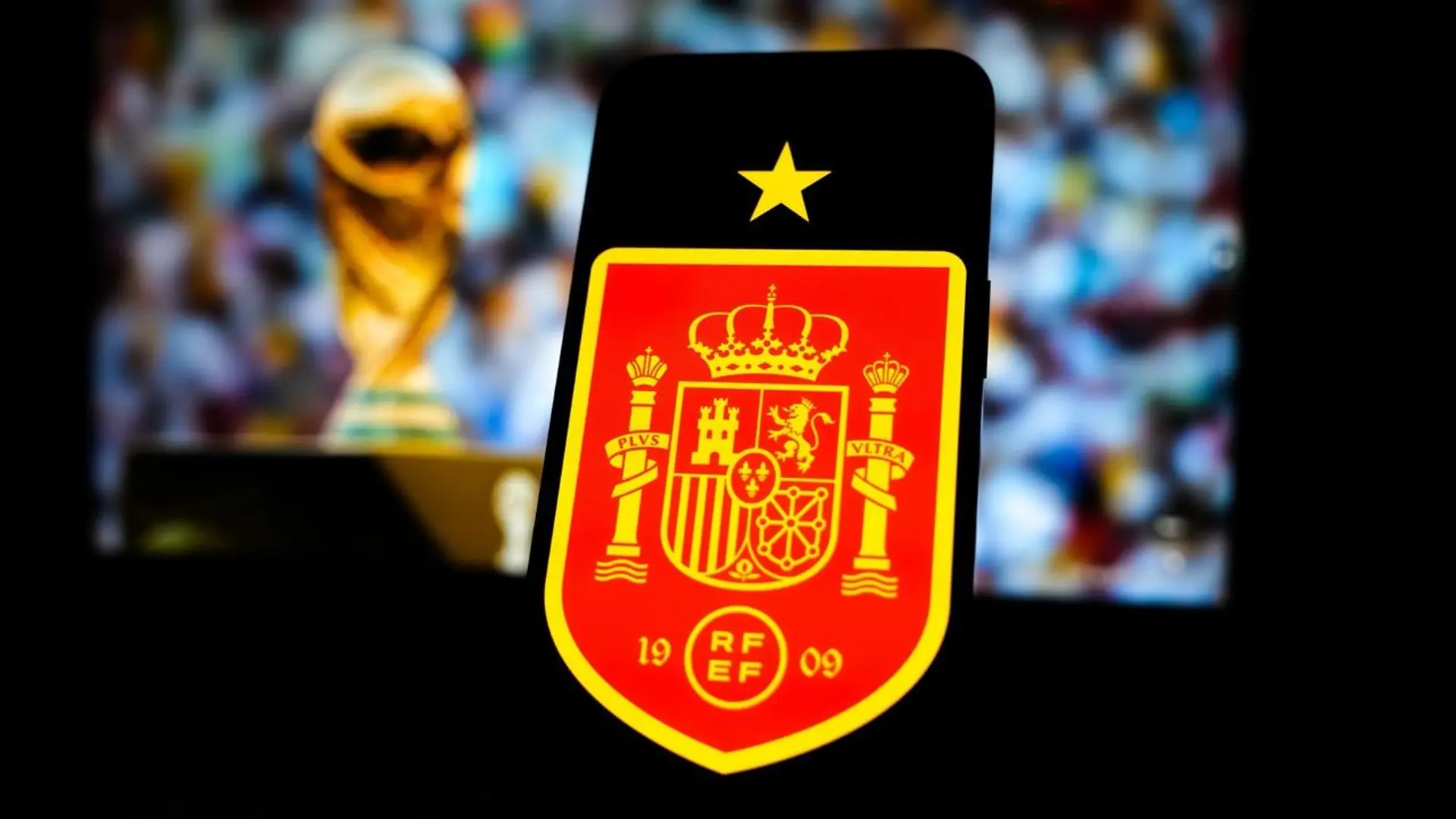 Spain crest and World Cup trophy displayed on a phone after the national team’s second men’s World Cup title