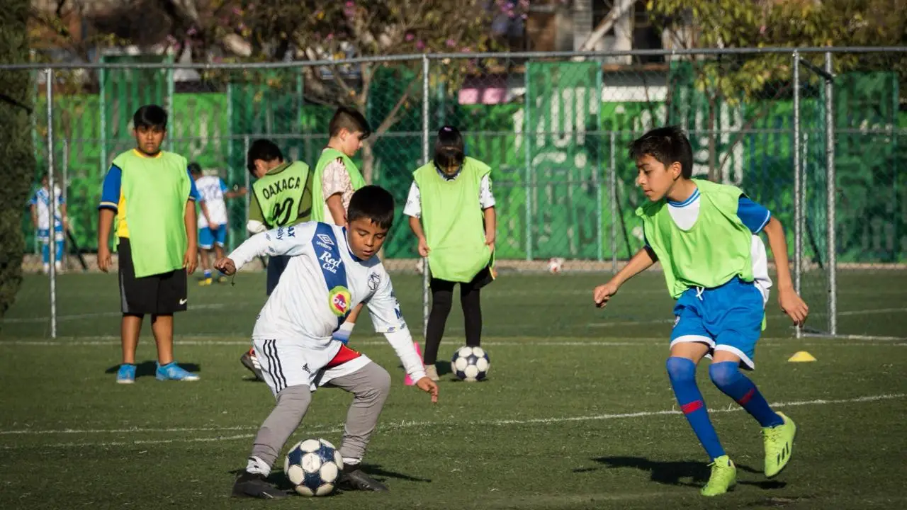 Children playing football on a community pitch in Mexico City