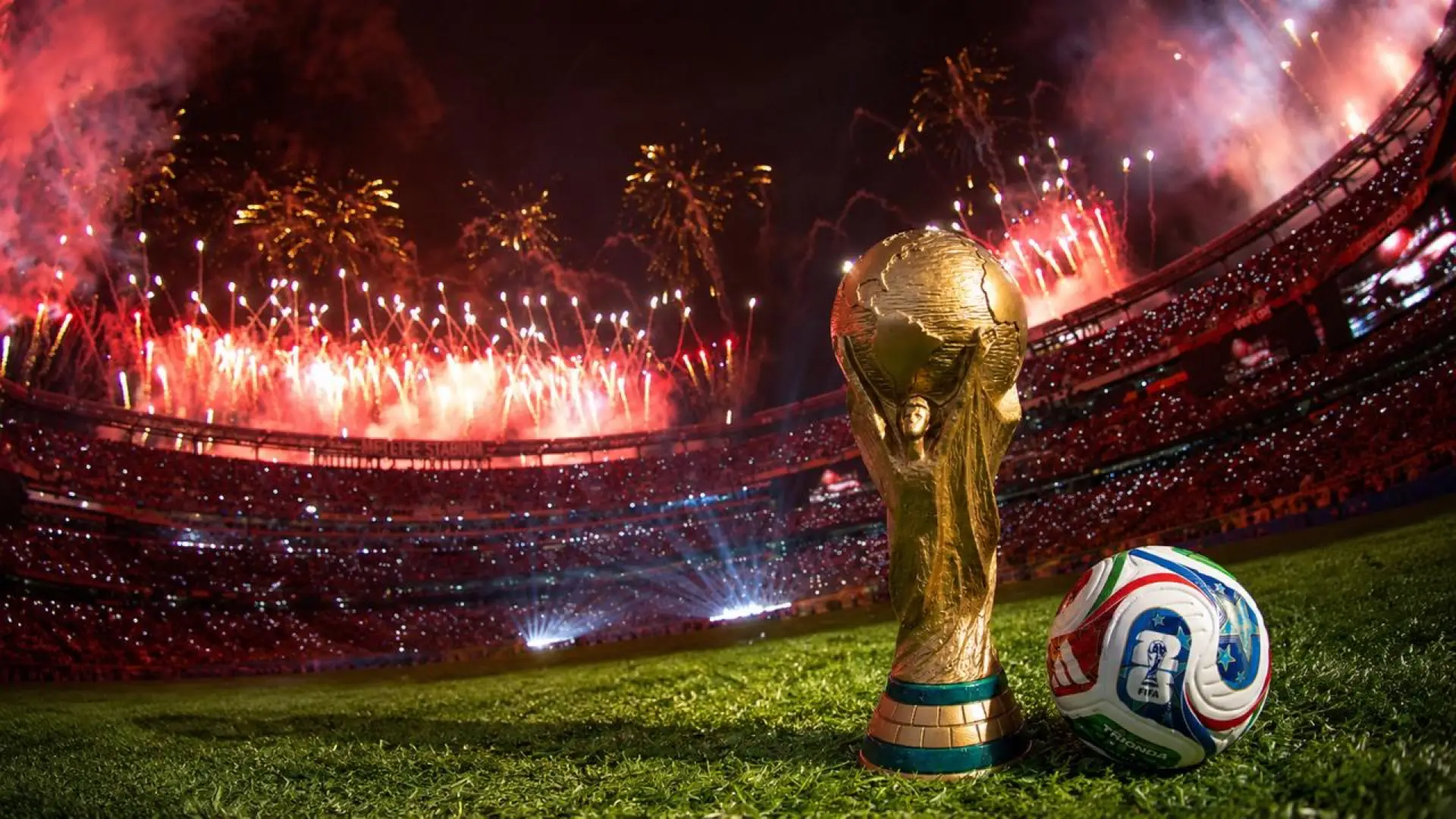 Illustration of the World Cup trophy and a match ball beneath stadium fireworks