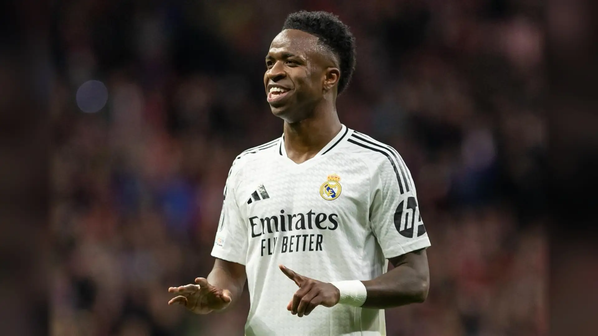 Vinicius Junior smiling in a white Real Madrid jersey on the pitch
