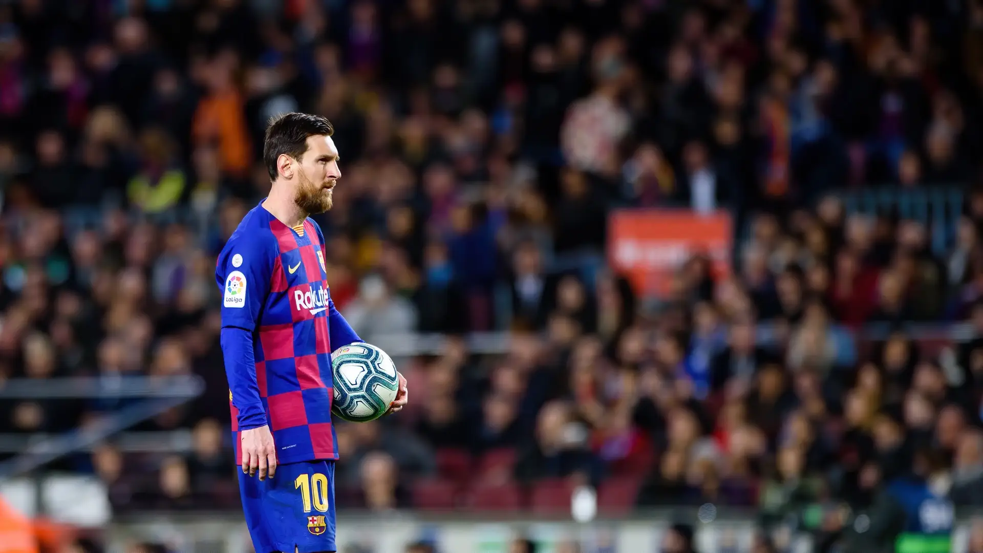 Lionel Messi holds a football in Barcelona’s blue and red home kit during a La Liga match.