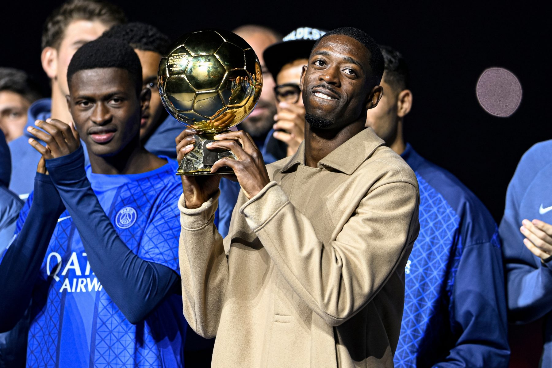 Ousmane Dembélé holds the Ballon d’Or trophy beside PSG teammates