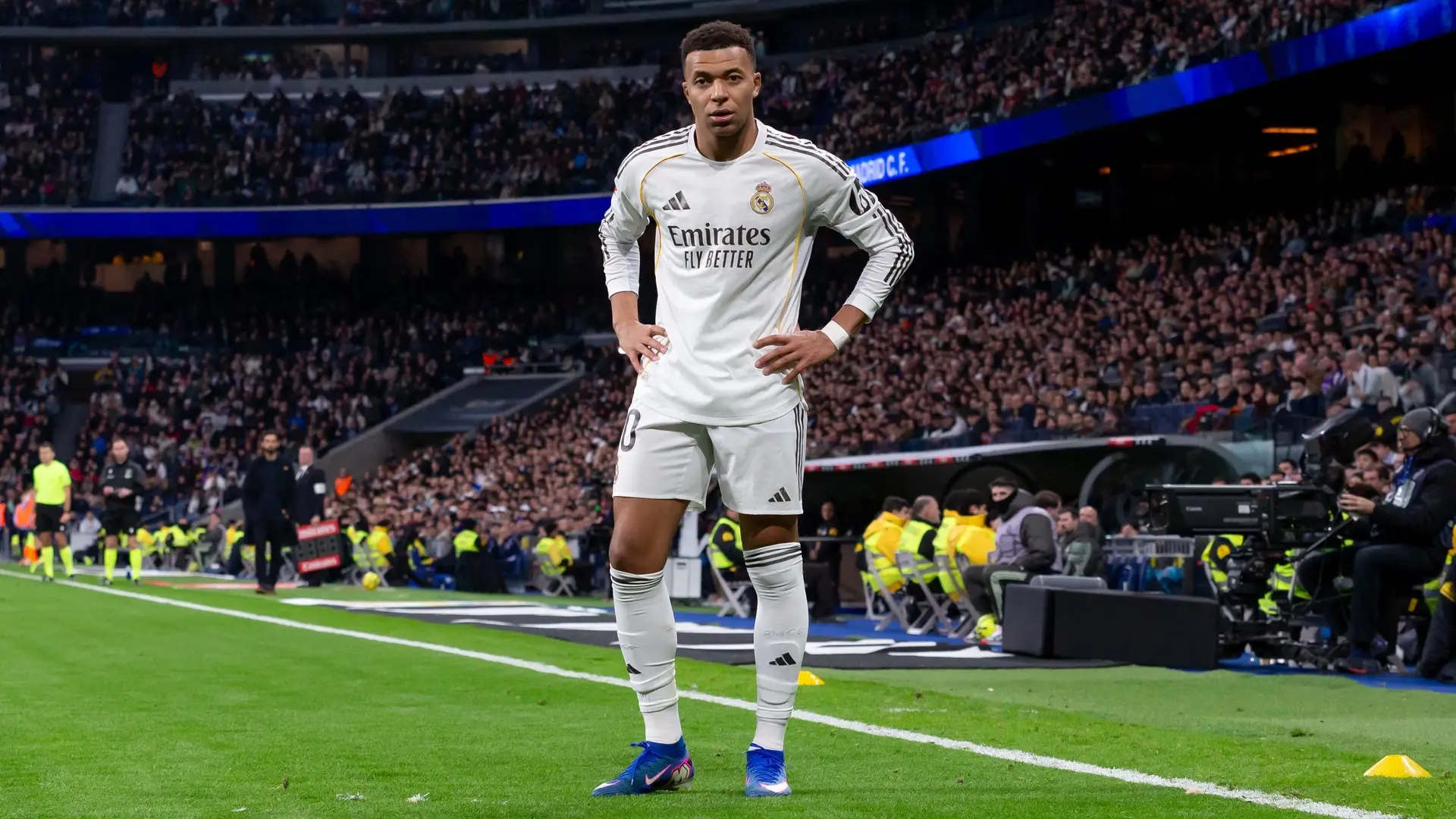 Kylian Mbappé stands on the touchline for Real Madrid
