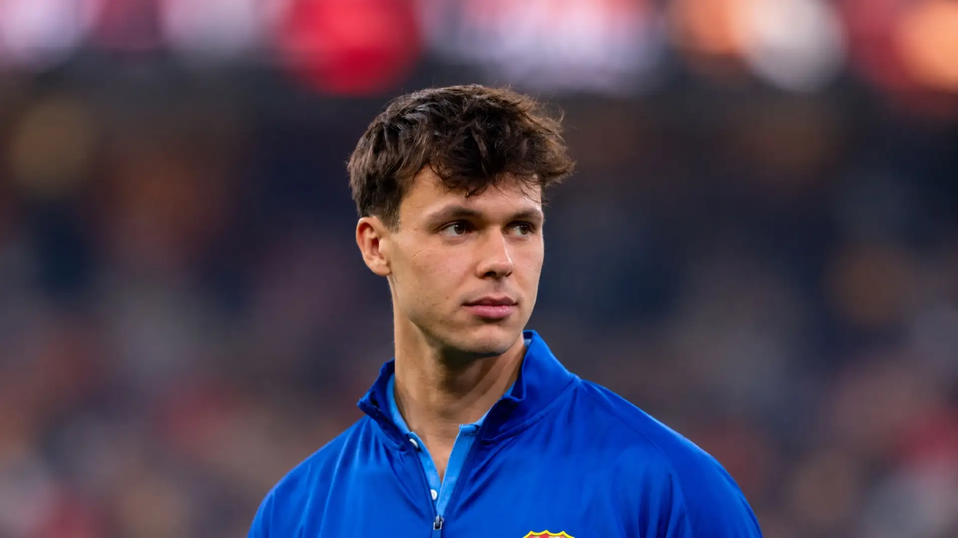 Diego Kochen wearing a blue Barcelona jacket at a stadium