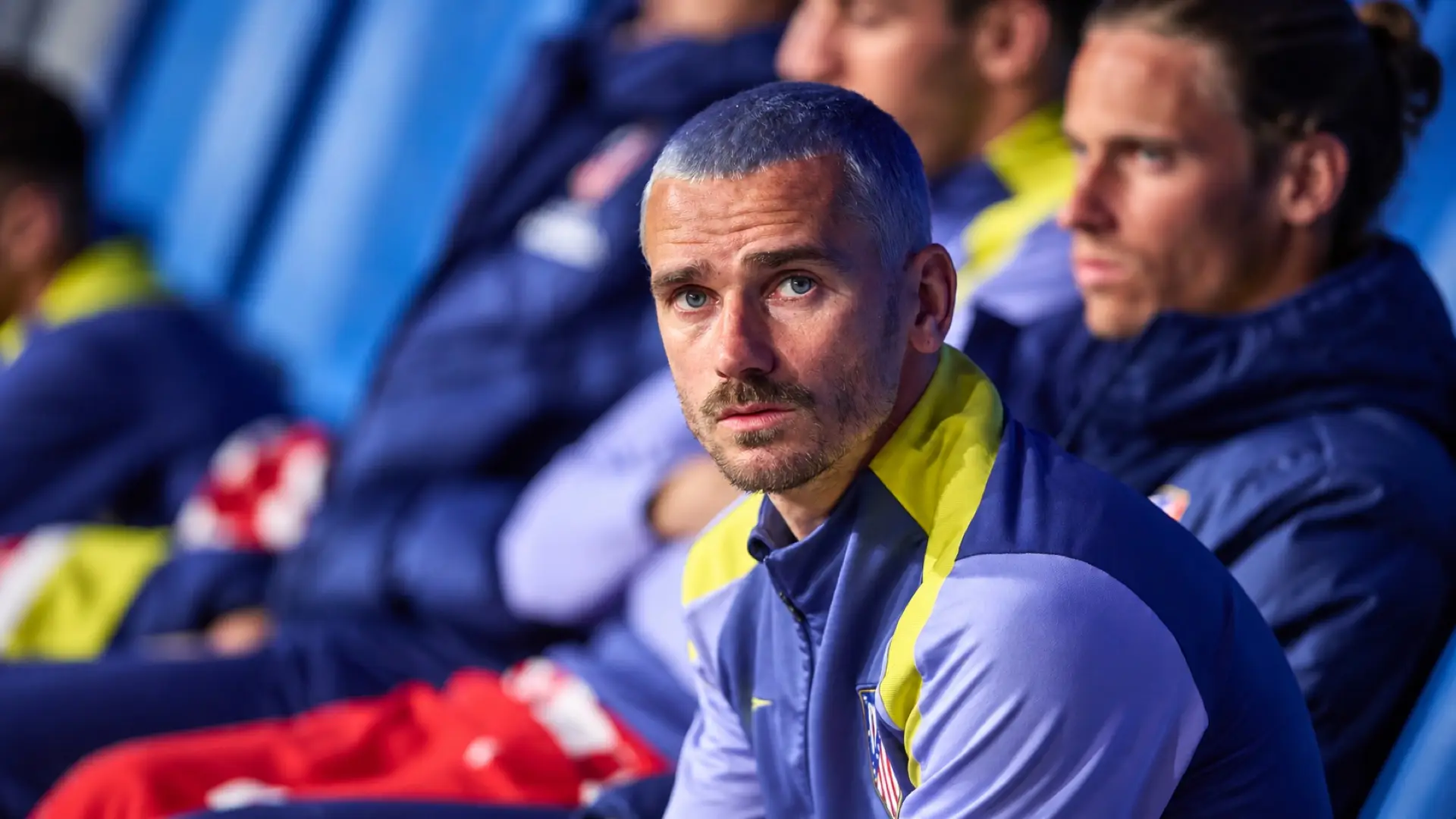 Antoine Griezmann seated on the bench in an Atlético Madrid training jacket