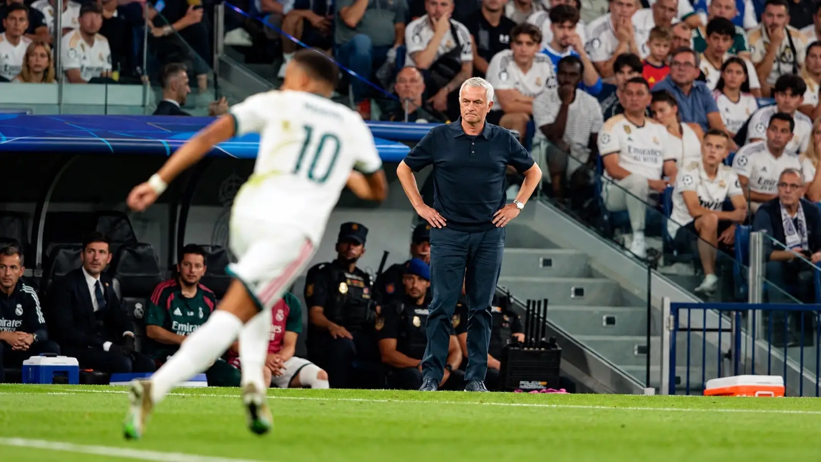José Mourinho watches from the touchline as a Real Madrid player runs past.