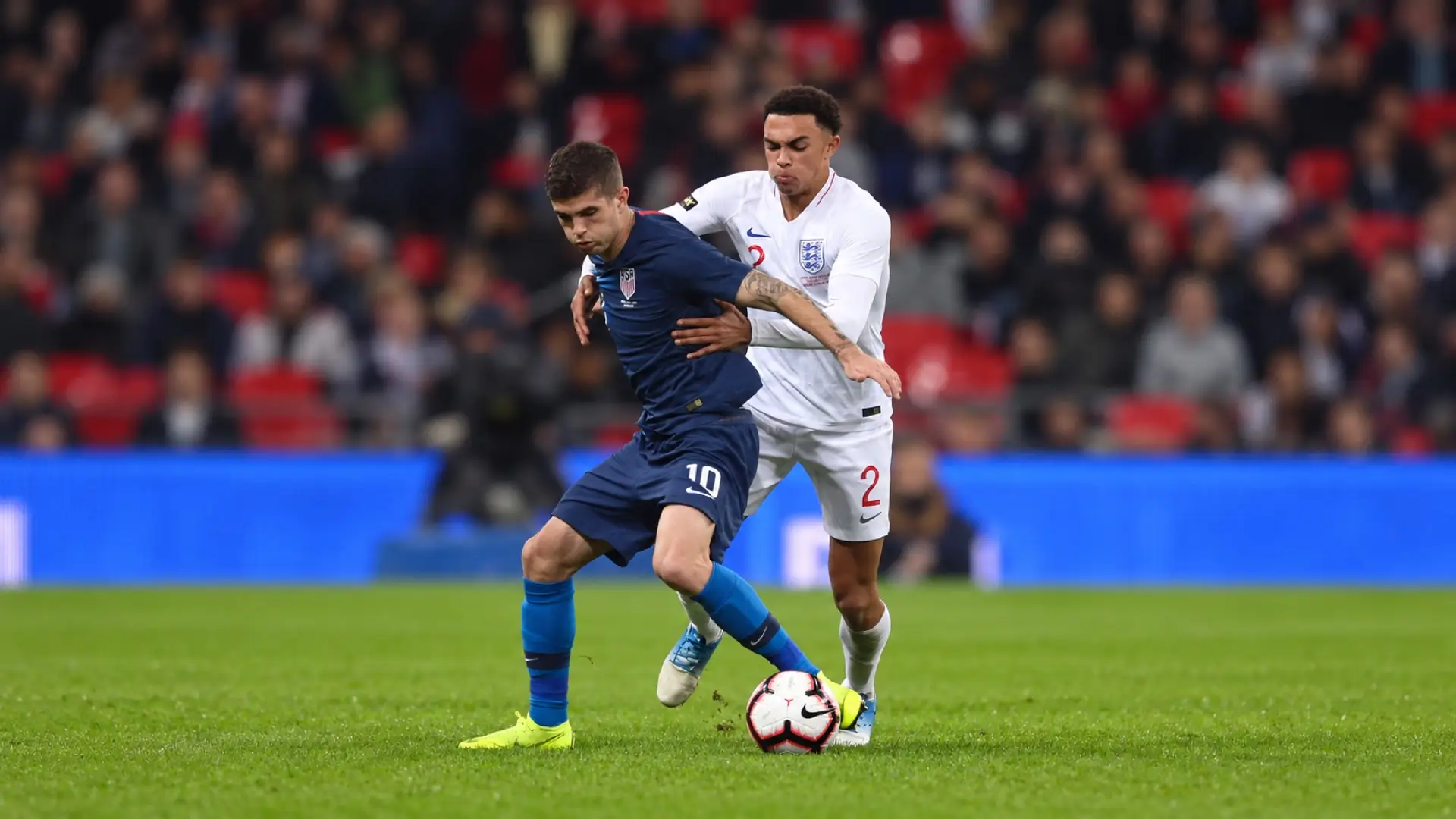 Christian Pulisic shields the ball from an England defender while playing for the United States.